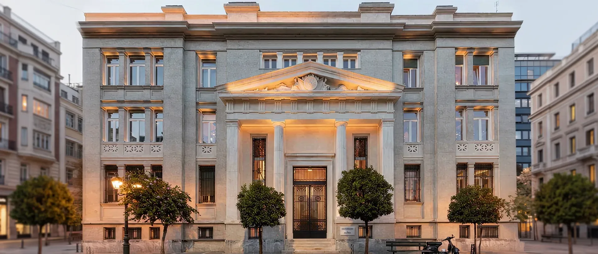 Η πρόσοψη του ιστορικού κτιρίου στη Μητροπόλεως, με τη στοά και τις κολόνες, το σούρουπο